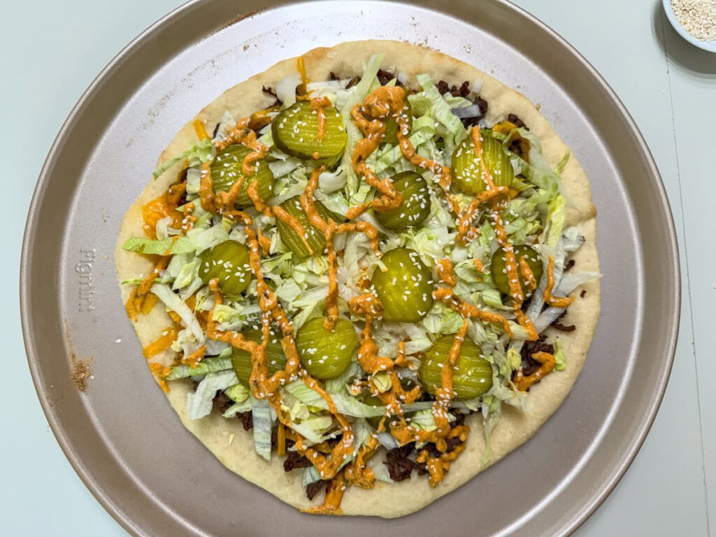 The onion, lettuce, pickles, and special sauce added to the top of the shredded cheese.