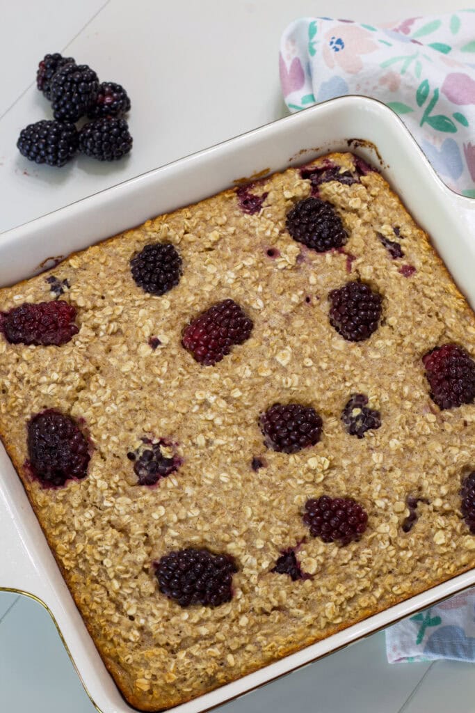 Overhead closeup of a square baking dish with uncut blackberry baked oatmeal.