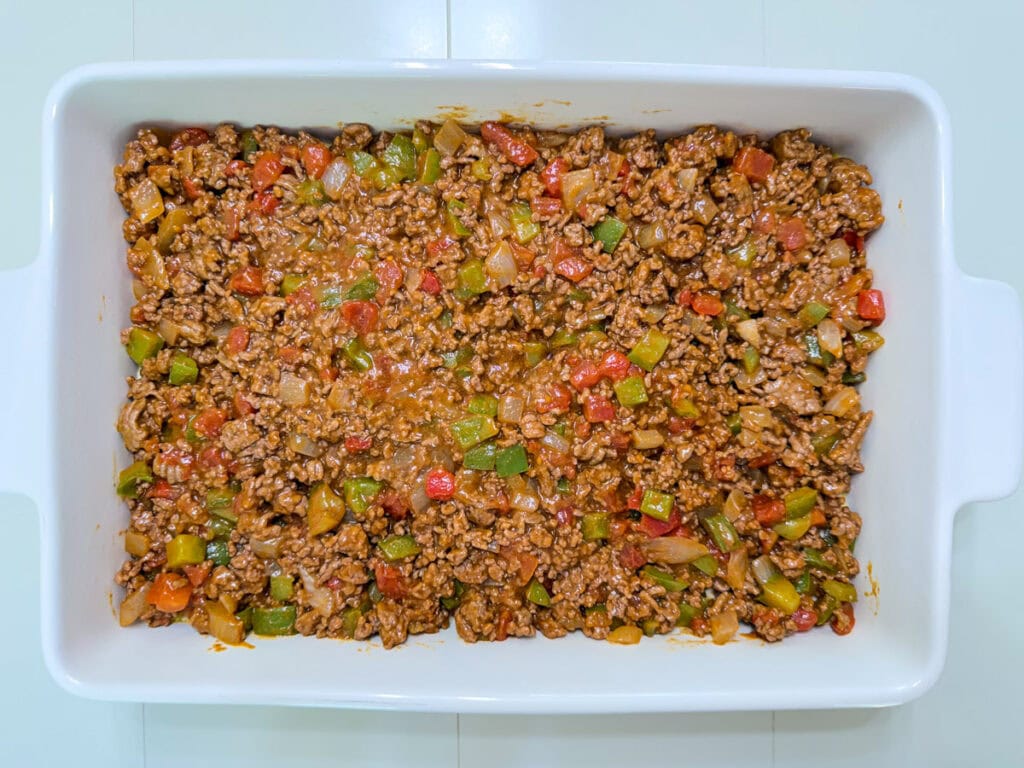 The ground beef mixture added onto the biscuit layer.