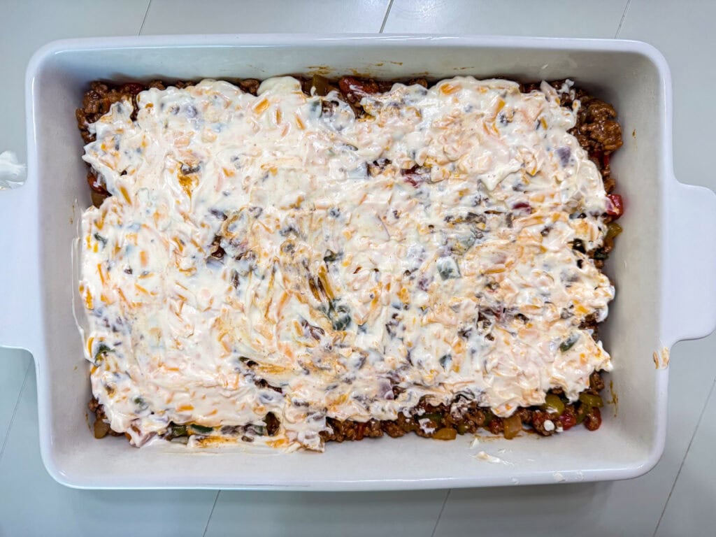 The sour cream and mayo layer on top of the ground beef layer.