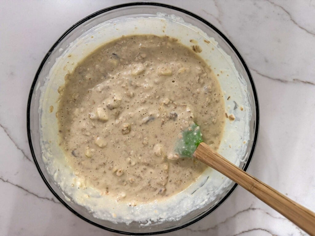 The mixed pancake batter in a large glass mixing bowl.