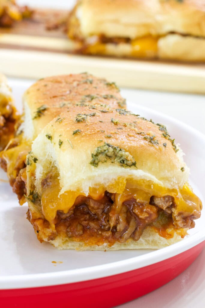 Closeup side view of one Sloppy Joe Slider where the meaty cheesy filling is visible.