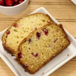 Closeup overhead of two slices of Cranberry Bread on a white plate.