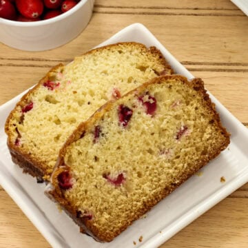 Closeup overhead of two slices of Cranberry Bread on a white plate.