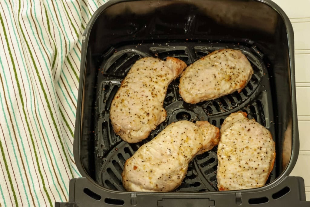 Overhead of four boneless pork chops that have been air fried.