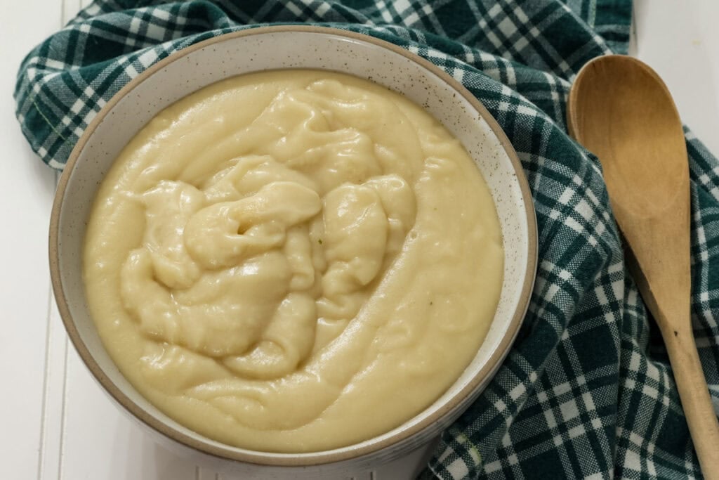 Closeup overhead of the cream of homemade chicken soup in a bowl so the texture is visible.