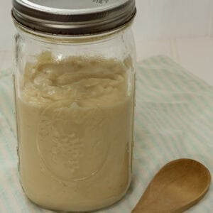 Very closeup downward side view of a mason jar about seventy-five percent full of homemade cream of chicken soup.