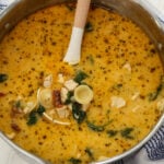 Overhead closeup of a large pot of Marry Me Chicken Soup with a ladle full in the center.
