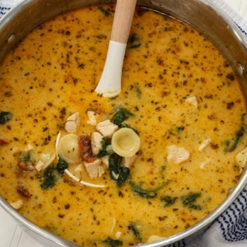 Overhead closeup of a large pot of Marry Me Chicken Soup with a ladle full in the center.